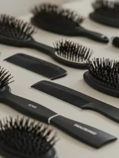 Variedad de cepillos y peines para diferentes tipos de cabello, destacando opciones para 2025.