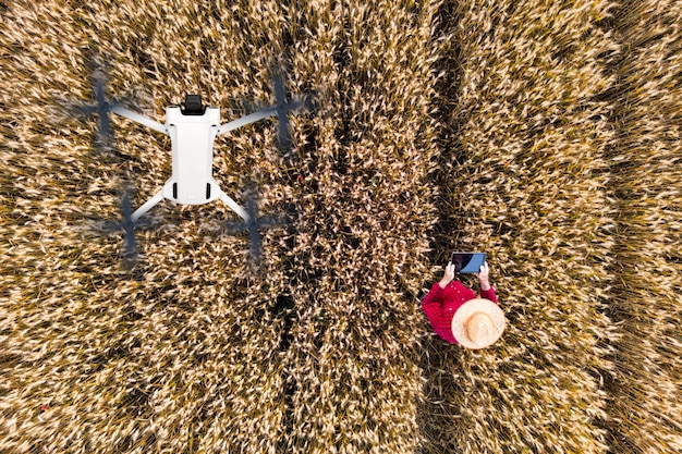 An aerial view of a large agricultural field being monitored by a drone, showcasing the use of technology in precision agriculture.