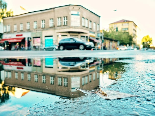 A close-up of a flooded street in a city, with cars partially submerged and water rising to the level of storefronts. The image captures the chaos and disruption caused by urban flooding.