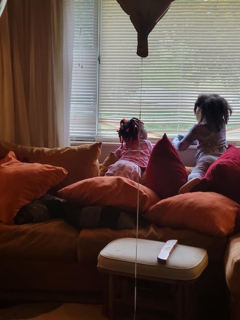 A worried family huddled together in their living room during a hurricane in Florida, using a hand-crank radio to listen for emergency broadcasts. The lights are out, and the storm rages outside. The image emphasizes the importance of non-traditional communication methods during disasters.