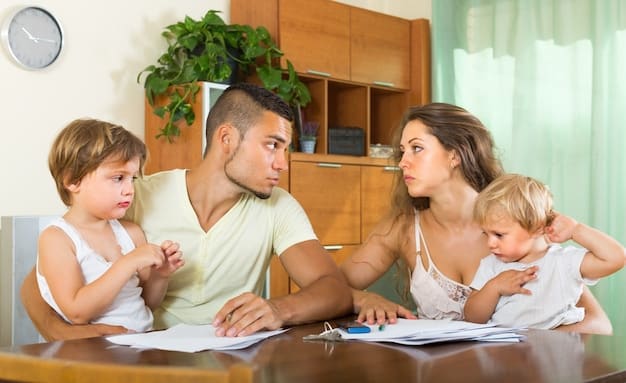 A picture of a family sitting at a table, reviewing their insurance policies. The policies are spread out on the table, and the family members are pointing and discussing them.