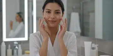 Rutina facial nocturna piel mixta 2025: Guía definitiva Mujer aplicando crema de noche en su piel mixta, con productos de cuidado facial modernos en el fondo.